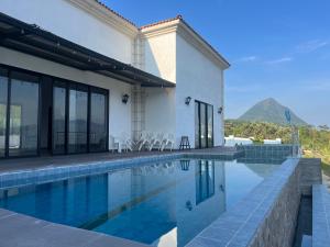 a house with a swimming pool with a mountain in the background at Villa Venecia Colonial in Venecia