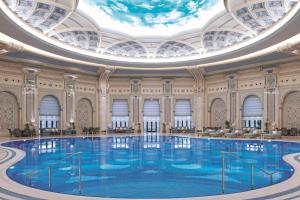 een groot zwembad in een gebouw met een gewelfd plafond bij The Ritz-Carlton, Riyadh in Riyad