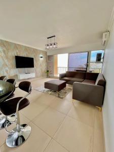 a living room with a couch and a table and chairs at 101 Camarque - Beachfront Apartment in Umdloti