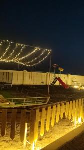 a park with a playground with lights at night at استراحة السهيلي بديه in Al Ghabbī