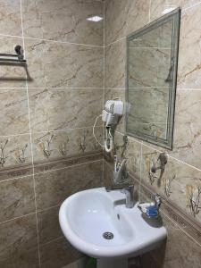 une salle de bain avec un lavabo et un miroir dans l'établissement Hotel Al-Bukhory, à Samarcande