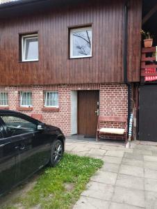 ein schwarzes Auto, das vor einem Haus geparkt ist in der Unterkunft Apartament przy plaży in Danzig