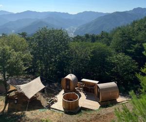 two wooden barrels and a tent with mountains in the background at Starry Sky and Sea of Clouds Hotel Terrace Resort - Vacation STAY 51669v in Takeda