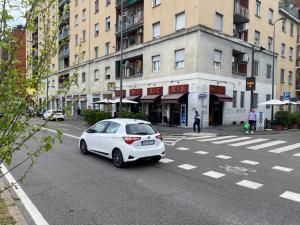 biały samochód zaparkowany po stronie ulicy w obiekcie BnB Milano Dipinta di Blu w Mediolanie