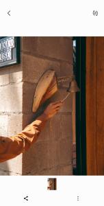 a person reaching for a light on a brick wall at IGUANA HOUSE in Máncora