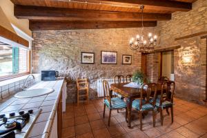 cocina y comedor con mesa y sillas en Casa Cobert del Carro, en Lladurs