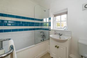 a bathroom with a tub and a sink and a shower at Salt Cellar Cottage in Aldeburgh +20 photos