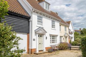 a white house with a black roof at Salt Cellar Cottage in Aldeburgh