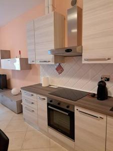 uma cozinha com armários de madeira e um forno com placa de fogão em Maria tre ponti em Sanremo