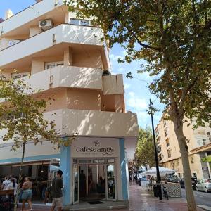 un edificio en una calle con gente caminando delante de una tienda en Apartamento Cristina 3 - Playa Arenal Bol, en Calpe