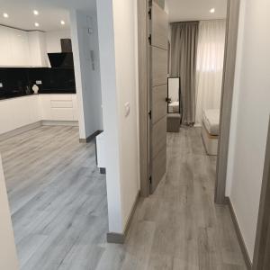 sala de estar con paredes blancas y suelo de madera. en Apartamento Cristina 3 - Playa Arenal Bol, en Calpe