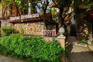 a sign in front of a building with a tree at Le Charcoa Hotel in Chiang Mai