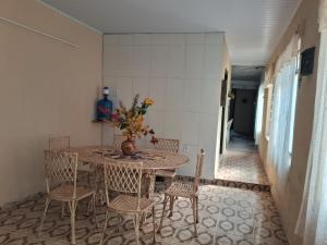 a dining room table with chairs and a vase of flowers at Casarão D'Ávila aluguel por temporada in Goiás +34 photos