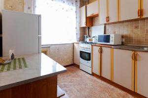 a kitchen with a white refrigerator and a microwave at Толедо in Petropavlovsk