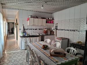 - une cuisine avec une table et des chaises dans la chambre dans l'établissement Casa por temporada, à Goiás