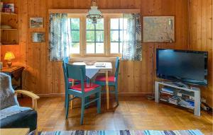 un soggiorno con tavolo e TV di Cozy Home In Isfjorden With House A Panoramic View a Tokle