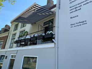 ein Gebäude mit einem Balkon mit Blumen darauf in der Unterkunft Kromme weele 26 in Middelburg