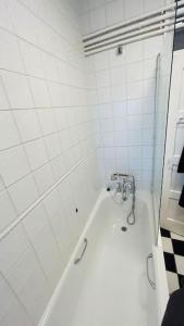 un bagno bianco con vasca e lavandino di Traditional 3 Bed Flat In Highgate a Londra