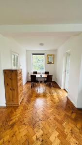a living room with a table and chairs and a window at Traditional 3 Bed Flat In Highgate in London