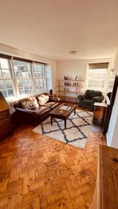 a living room with a couch and a table at Traditional 3 Bed Flat In Highgate in London