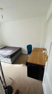 a room with a desk and a bed and a table at Traditional 3 Bed Flat In Highgate in London
