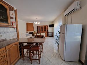 オバールにあるFuradouro - Apartamento Praiaのキッチン(冷蔵庫、テーブル、椅子付)