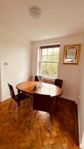 a dining room with a table and chairs and a window at Traditional 3 Bed Flat In Highgate in London