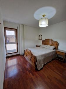a bedroom with a large bed and a window at Furadouro - Apartamento Praia in Ovar