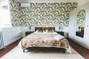 1 dormitorio con 1 cama y papel pintado con motivos florales en Chateau La Croix De Millorit, 
