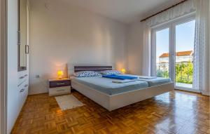 a bedroom with a bed and a large window at Amazing Apartment In Medulin With 3 Bedrooms And Wifi in Medulin
