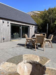 a patio with a table and chairs and a building at Raasay Studio Lodge in Arisaig