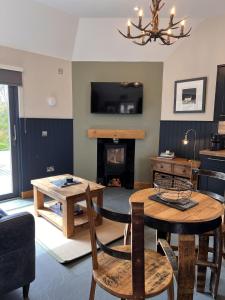 a living room with a table and a fireplace at Raasay Studio Lodge in Arisaig
