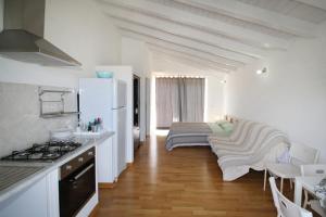 a kitchen with white walls and a stove top oven at La Gabbianella E Il Gatto in Acquedolci
