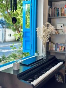 un piano assis sur une table avec une porte bleue dans l'établissement Loka Home & Yoga, à Đà Nẵng