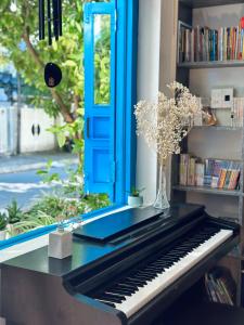 a piano sitting on a table with a blue door at Loka Home & Yoga in Da Nang