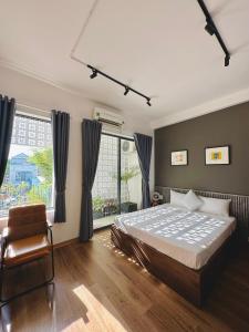 - une chambre avec un lit, une chaise et une fenêtre dans l'établissement Loka Home & Yoga, à Đà Nẵng