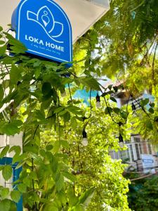un panneau pour la maison suspendu à un arbre dans l'établissement Loka Home & Yoga, à Đà Nẵng