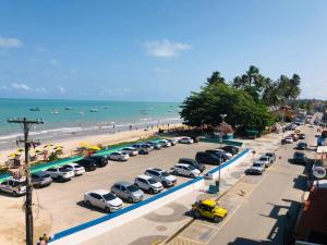 un montón de coches aparcados en un estacionamiento junto a la playa en Fabika Pousada en Maragogi