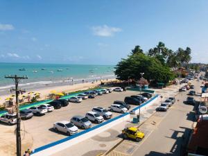 a bunch of cars parked in a parking lot next to the beach at Fabika Pousada in Maragogi