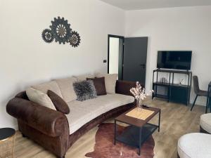 sala de estar con sofá marrón y mesa en M.F., en Znojmo