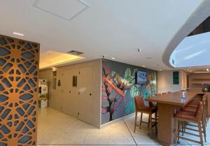 a dining room with a table and a painting on the wall at JP CRAUFORD HOSPEDAGEM LORENA in São Paulo