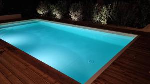- une piscine avec éclairage bleu sur une terrasse dans l'établissement Les Chalets du Golf de Biscarrosse, à Biscarrosse
