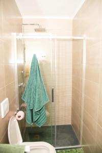 y baño con ducha y toalla verde. en Reihenhaus in Alcanar mit Garage, en Alcanar