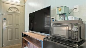 cocina con microondas, TV y puerta en Blue Jay Lodge en South Lake Tahoe