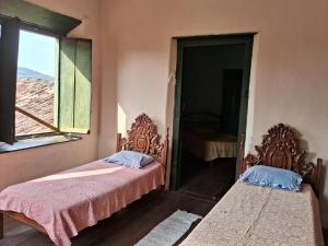 two beds in a room with a window at Casa por temporada in Goiás