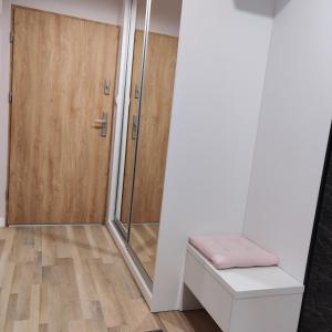 łazienka z prysznicem, ławką i drzwiami w obiekcie Apartament Perła Kutna w Kutnie