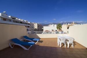 a balcony with chairs and tables on a roof at Apartamentos Turísticos Fercomar in Nerja