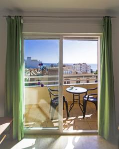 a balcony with a table and a view of the city at Apartamentos Turísticos Fercomar in Nerja
