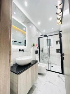 y baño con lavabo, aseo y ducha. en Apollo 2 bd jacuzzi suite en Athens