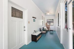 a hallway with blue floors and a white door at Redstick Cottage in Baton Rouge
